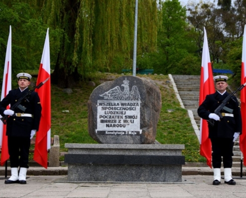 Pomnik Konstytucji 3 Maja z wartą honorową Marynarki Wojennej i flagami Polski